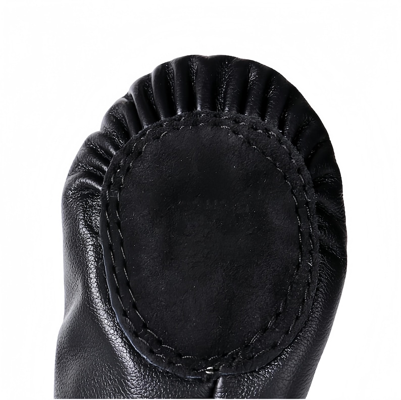 A close-up view of a black leather shoe sole with a circular, embossed design.