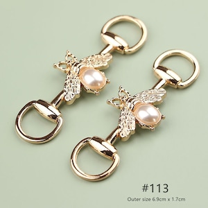 Puede incluir: Dos hebillas de zapatos doradas en forma de abeja con un acento de perla. Cada hebilla tiene un anillo en forma de D y mide 6,9 cm x 1,7 cm. #113