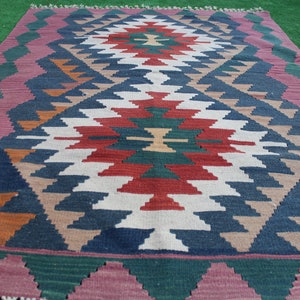 Puede incluir: Una alfombra tradicional con un patr&oacute;n geom&eacute;trico en tonos rojos, azules, verdes y marrones. La alfombra tiene un borde con flecos y est&aacute; tejida con una variedad de texturas.