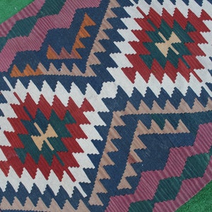 Puede incluir: Una alfombra colorida con un patr&oacute;n geom&eacute;trico en tonos de rojo, verde, azul, blanco y marr&oacute;n. La alfombra tiene un dise&ntilde;o tradicional con detalles intrincados.