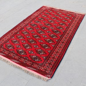 Puede incluir: Una alfombra roja con un dise&ntilde;o persa tradicional. La alfombra tiene un borde con flecos y est&aacute; hecha de lana.