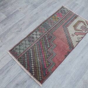 Peut inclure: Un tapis turc vintage avec un motif géométrique rose, rouge, vert et bleu. Le tapis a une bordure à franges et est fait de laine.