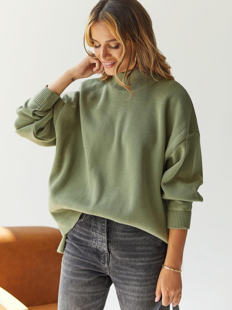 Puede incluir: Un su&eacute;ter de cuello alto verde salvia con mangas largas y un corte holgado.