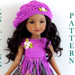 May include: A purple knitted doll outfit with a matching beret. The outfit has a fringe trim and a flower embellishment. The doll has long brown hair.