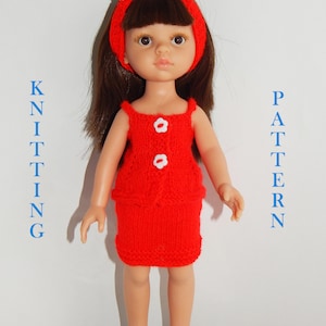 May include: A red knitted dress and matching headband with white flower accents for a doll. The doll has brown hair and blue eyes.