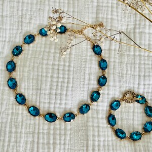 K&ouml;nnte beinhalten: Ein Set aus zwei t&uuml;rkisblauen Kristallketten mit ovalen Steinen. Die gr&ouml;&szlig;ere Kette ist ein Choker und die kleinere Kette ist ein Armband.