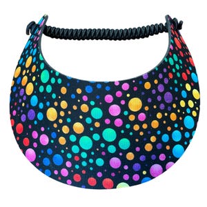 May include: A colorful visor with a black background and a pattern of vibrant, multicolored polka dots. The visor has a black elastic band for a secure fit and is designed to shield the eyes from the sun.