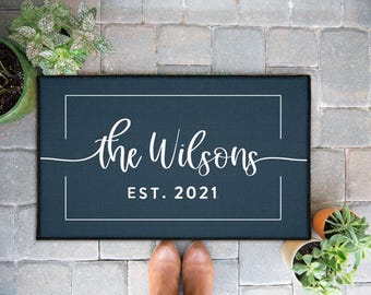 May include: A dark blue welcome mat with white text that reads "The Wilsons Est. 2021".