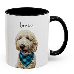 May include: White ceramic mug with a black handle and rim. The mug features a portrait of a Goldendoodle dog wearing a blue and teal plaid bandana. The dog's name, "Louie," is written above the dog's head in black script.