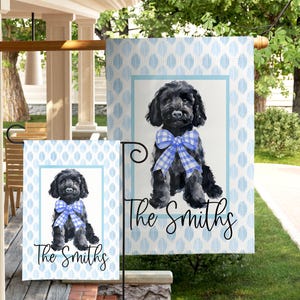 May include: A personalized garden flag featuring a black dog with a blue and white checkered bow tie. The flag has a light blue and white diamond pattern background and the name "The Smiths" in script.