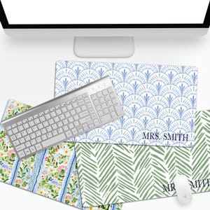 May include: Three rectangular desk mats featuring distinct patterns: one with a blue and white fan-like motif labeled "MRS. SMITH," one with a green and white leaf pattern labeled "MRS. SMITH," and one with a colorful floral print, plus a keyboard and mouse.