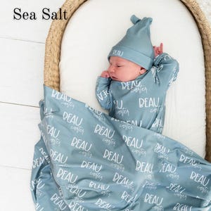 Personalized baby swaddle blanket with custom name, ideal for newborn photography, hospital swaddle photos, and first announcement pictures. Soft, cozy name swaddle set creates a memorable keepsake and popular baby gift for new parents.