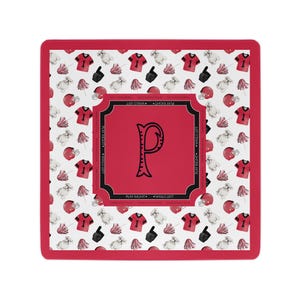 May include: A square mat with a red border and a white background featuring a repeating pattern of red football jerseys with the number one, red helmets, white bulldogs, black foam fingers, and red pom-poms. A central red square displays a black letter P.