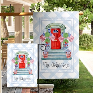 May include: Two rectangular garden flags featuring a light blue and white gingham pattern border. The center illustration depicts a red front door with green topiaries, American flags, and red and white plaid planters. The text The Johnsons is printed below.