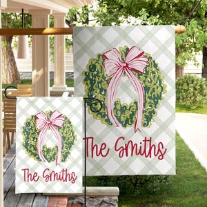 Peut inclure: Deux drapeaux de jardin avec un motif de couronne et un nœud rose. La couronne est verte avec des accents rouges. Le texte "The Smiths" est en écriture rouge. Le fond est un motif à carreaux vert clair et blanc.