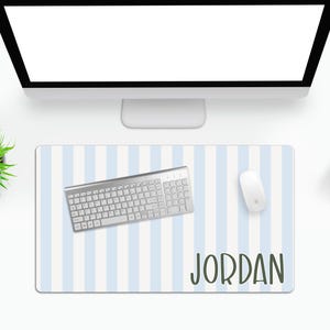 May include: A blue and white striped desk mat with the name "JORDAN" printed in green. A silver keyboard and a white mouse are on the mat.