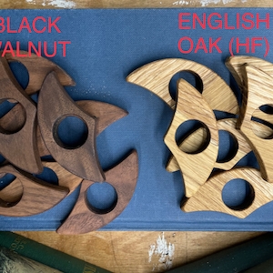 Op de afbeelding: Twee sets houten ringen, &eacute;&eacute;n set in zwarte walnoot en &eacute;&eacute;n set in Engelse eik (HF). De ringen zijn halfrond met een gat in het midden.
