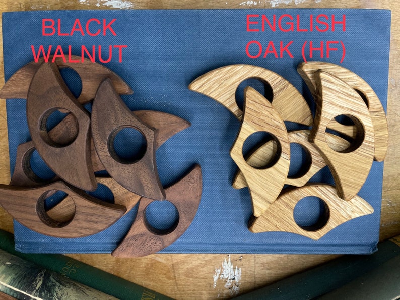 Op de afbeelding: Twee sets houten ringen, &eacute;&eacute;n set in zwarte walnoot en &eacute;&eacute;n set in Engelse eik (HF). De ringen zijn halfrond met een gat in het midden.