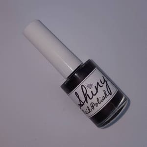 May include: A bottle of black nail polish with a diamond logo and the text "Shiny Nail Polish" on the label.
