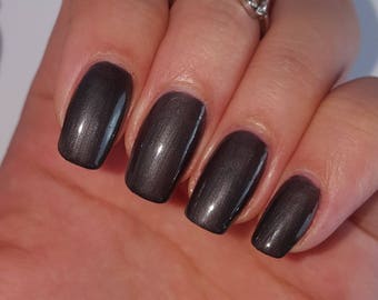 May include: Close-up of a hand with five fingernails painted with a dark, metallic gray nail polish.
