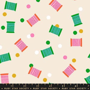 May include: A light beige fabric featuring a repeating pattern of teal and pink thread spools with orange ends, interspersed with small solid circles in green, yellow, pink, and white. A black ruler with the text RUBY STAR SOCIETY is visible.