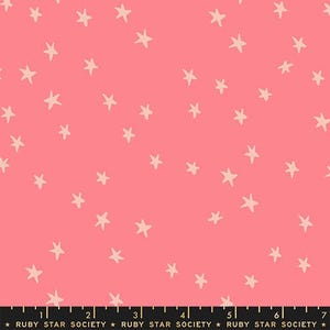 May include: Pink fabric with a pattern of scattered, light beige stars. The fabric has a ruler along the bottom with the text "RUBY STAR SOCIETY". This fabric is suitable for quilting, sewing, and crafting projects.