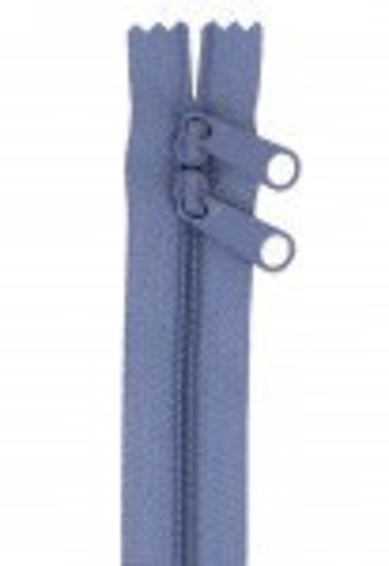 May include: A light blue zipper with two metal sliders and two metal pull tabs.