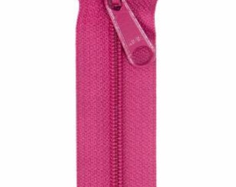 May include: A close-up of a magenta zipper against a white background. The zipper is open, with the two sides of the fabric separated. The zipper pull is a matching magenta color.