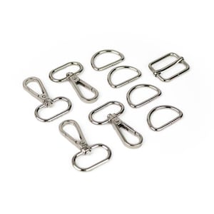 May include: A set of silver metal hardware for bags and accessories. The set includes four swivel clasps, three D-rings, and two rectangular buckles.