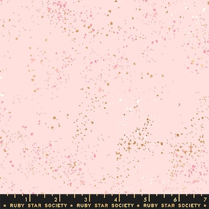 May include: Pink fabric with a speckled pattern of gold, white, and pink dots. The fabric has a soft, light pink background. The dots vary in size and density, creating a textured effect. The text "RUBY STAR SOCIETY" is at the bottom.