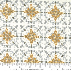May include: Cream-colored fabric with a repeating pattern of stylized yellow and gray flowers, bees, and swirling vines. The design is arranged in a grid, creating a symmetrical and decorative effect. The fabric has a ruler along the bottom edge.