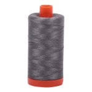 May include: A spool of gray thread with an orange base and top. The thread is tightly wound around the spool, and the orange top is slightly tapered. The thread is likely for sewing or embroidery projects.