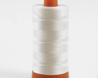 May include: A spool of white thread with an orange plastic bobbin.
