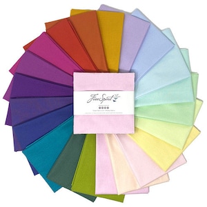 May include: A collection of 20 fabric squares in a rainbow of colors, arranged in a circle. The squares are all the same size and are made of a soft, cotton fabric. The fabric squares are labeled "Free Spirit" in the center of the circle.