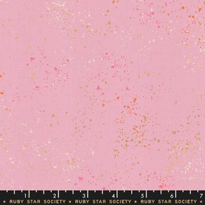 May include: Pink fabric with a speckled pattern of gold, white, and pink dots. The fabric has a ruler with the text "RUBY STAR SOCIETY" printed on it.