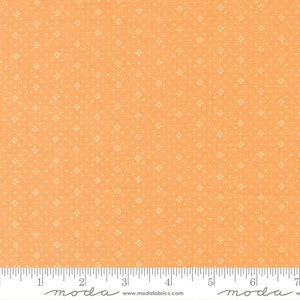 May include: Peach-colored fabric with a white, repeating diamond pattern. The fabric is shown with a ruler for scale.