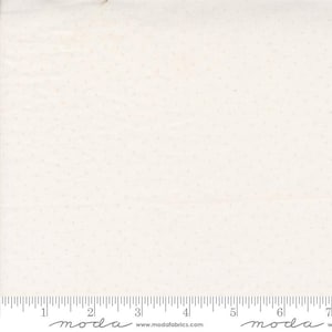 May include: White fabric with a subtle, evenly spaced pattern of tiny pink dots. The fabric is shown with a ruler, with the text "moda" printed on the ruler.