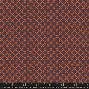 May include: A fabric with a repeating pattern of orange square-like shapes on a dark purple background. The pattern creates a grid-like design. The bottom of the image has a ruler with measurements in inches and the text "RUBY STAR SOCIETY".
