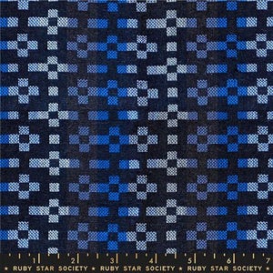May include: A dark blue fabric with a geometric pattern of squares and crosses in shades of blue and white. The fabric has a woven texture and a ruler along the bottom edge. The text "RUBY STAR SOCIETY" is printed along the bottom.