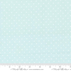 May include: A light blue fabric with a white polka dot pattern. The fabric is shown with a ruler for scale. The ruler shows the text "moda" and the website "www.modafabrics.com".