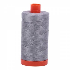 May include: A spool of gray thread with an orange top and base. The thread is tightly wound around the spool, creating a cylindrical shape. The thread appears to be a medium weight, suitable for various sewing projects.