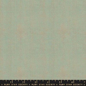 May include: A solid green fabric with a subtle texture. The fabric has a slightly faded look, giving it a vintage feel.