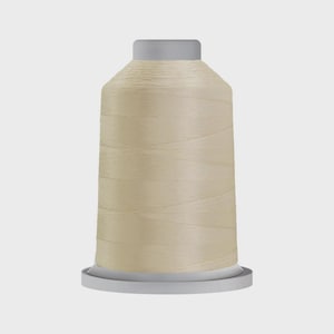 May include: A spool of beige thread, ideal for sewing and embroidery projects. The thread is tightly wound on a cylindrical spool with a gray top and base. The thread has a smooth, slightly shiny appearance.