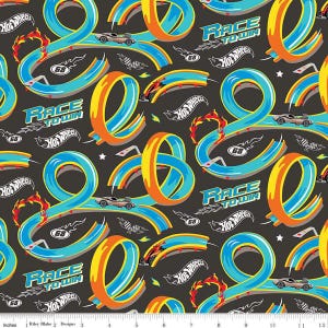May include: A black and blue fabric with a repeating pattern of Hot Wheels race tracks, cars, and the words "Race to Win".