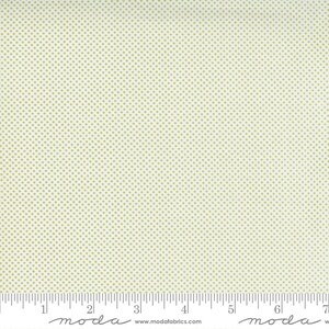 May include: White fabric with a small green polka dot pattern. The fabric is measured with a ruler in inches.