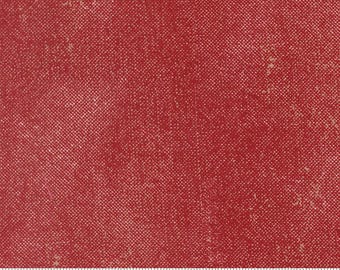 Könnte beinhalten: Ein roter Stoff mit texturierter, gesprenkelter Optik und einem feinen Kreuzschraffurmuster. Ein weißes Maßband liegt am unteren Rand und zeigt eine Skala in Zentimetern, die über 18 cm hinausgeht, mit dem sichtbaren Text moda fabrics.