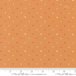 May include: Orange fabric with a repeating pattern of small, evenly spaced polka dots in shades of red, pink, and white. The fabric has a ruler along the bottom edge.
