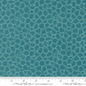 May include: Teal fabric with a repeating pattern of overlapping white circles. The fabric has a textured appearance and is suitable for quilting or other craft projects. The image includes a ruler along the bottom edge.