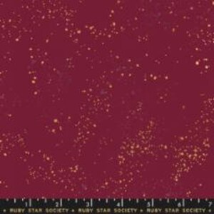 May include: A deep red fabric with a scattered pattern of small gold dots.