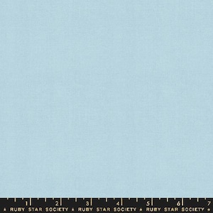 May include: A solid light blue fabric with a subtle texture. The fabric is shown with a ruler marked in inches.
